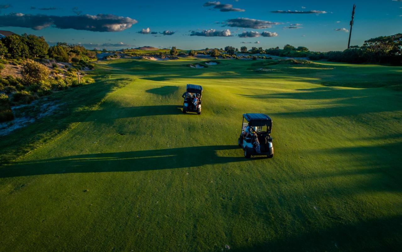 Pullman Magenta Shores Resort Entrance Esterno foto Golf carts on the green